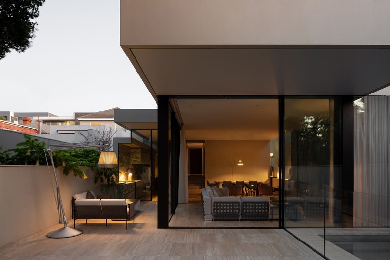 Terrace with full-height glazing opening onto the living room at dusk