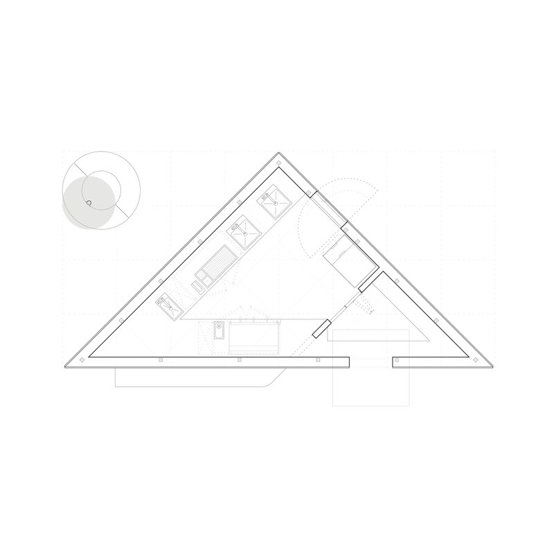 Floor plan drawing showing a triangular structure with interior rooms and a circular element to the left