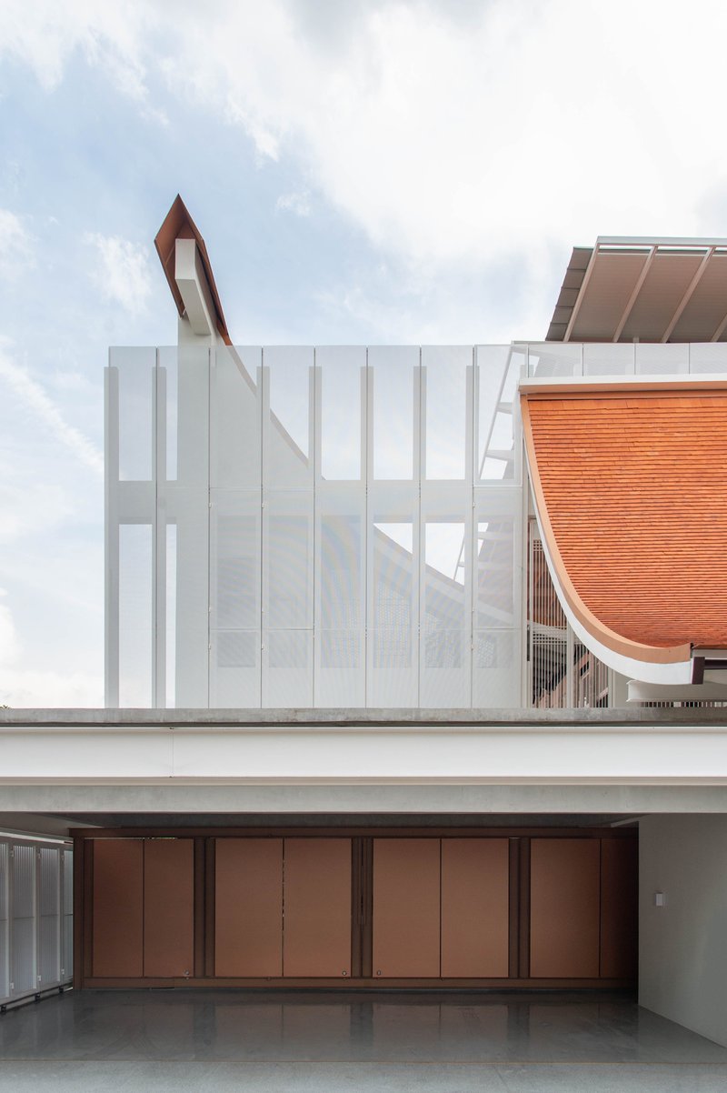 Upper level terrace showing white panel walls and copper folding doors beneath the curved roof overhang