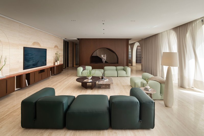 Living area with arched brown-toned wall niche and sheer curtains along the window wall