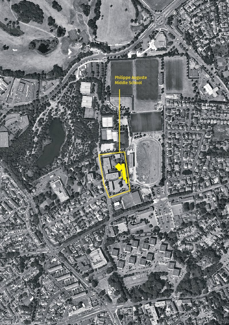 Aerial site plan diagram showing building footprint highlighted in yellow within surrounding neighborhood