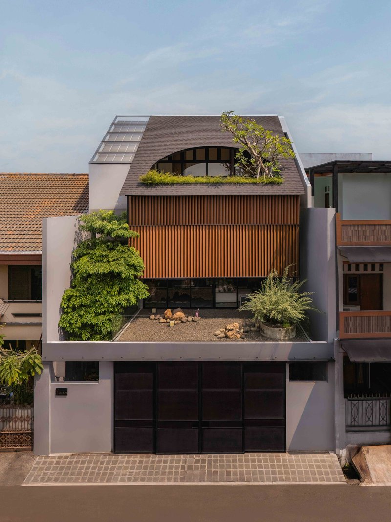 Front elevation showing curved shingle roof, timber screen wall, and planted terrace below