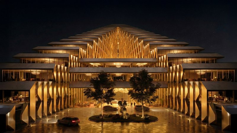Symmetrical facade with vertical fins framing a central courtyard with trees and fountain at night