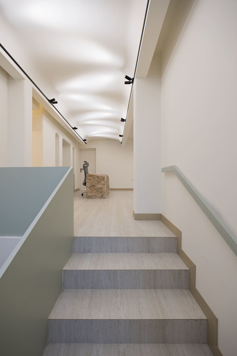 Upper landing with pale wood flooring and linear track lighting leading toward interior doorways