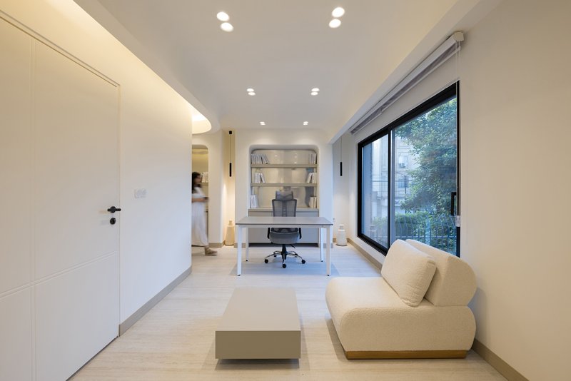 Home office with built-in shelving and large glazed door overlooking green foliage outside
