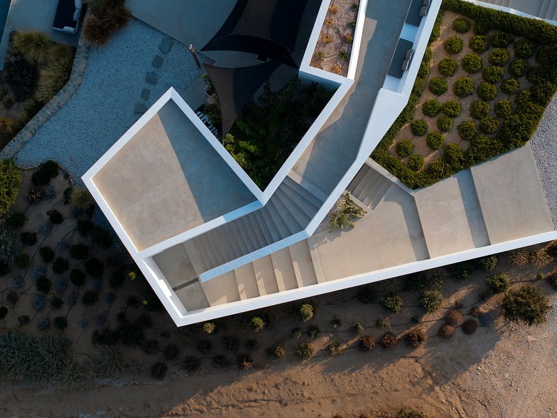 Drone view of the white flat roof volumes with courtyards and surrounding planted beds