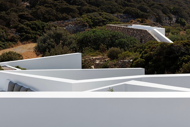 Overlapping white rooflines cascading down the hillside amid native vegetation