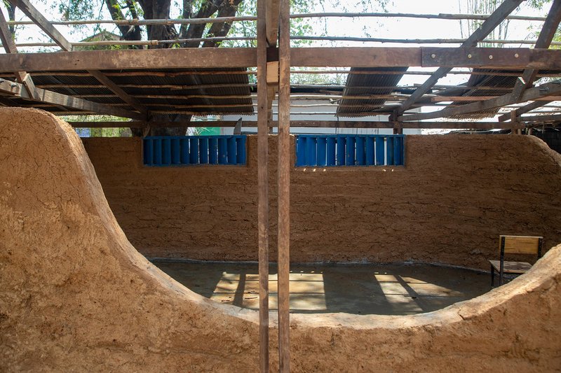 &nbsp; Interior view showing curved earthen walls shaping a flexible and open learning space.