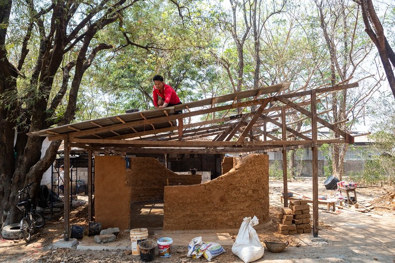 &nbsp; Timber roof structure assembled over hand-sculpted earth walls in a low-cost classroom build.&nbsp;