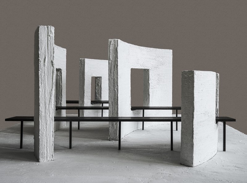 Physical model showing white textured panels with openings supported by black steel frames