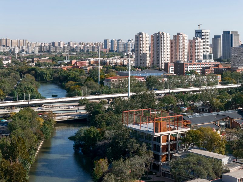 Aerial view of the rooftop steel frame above the structure with river and highway infrastructure in background