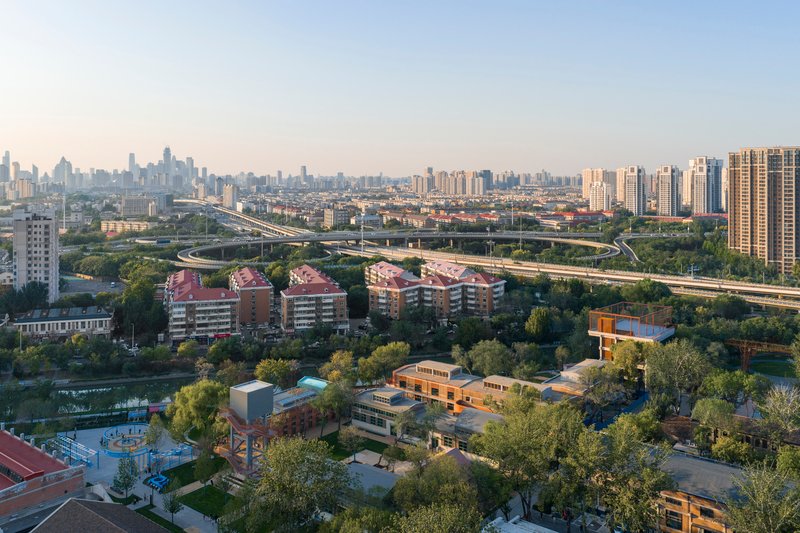 Drone view of the campus with planted grounds and surrounding residential towers at dusk