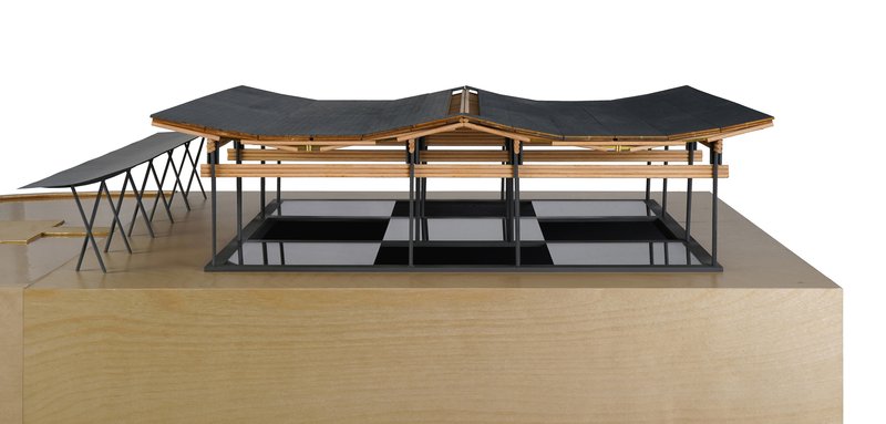 Physical model displaying the timber roof structure with dark cladding over a raised plinth base