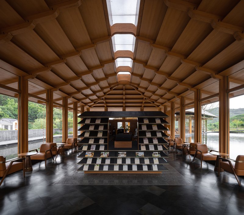 Interior hall with barrel-vaulted timber ceiling, skylights, and chequered black and white tile feature wall