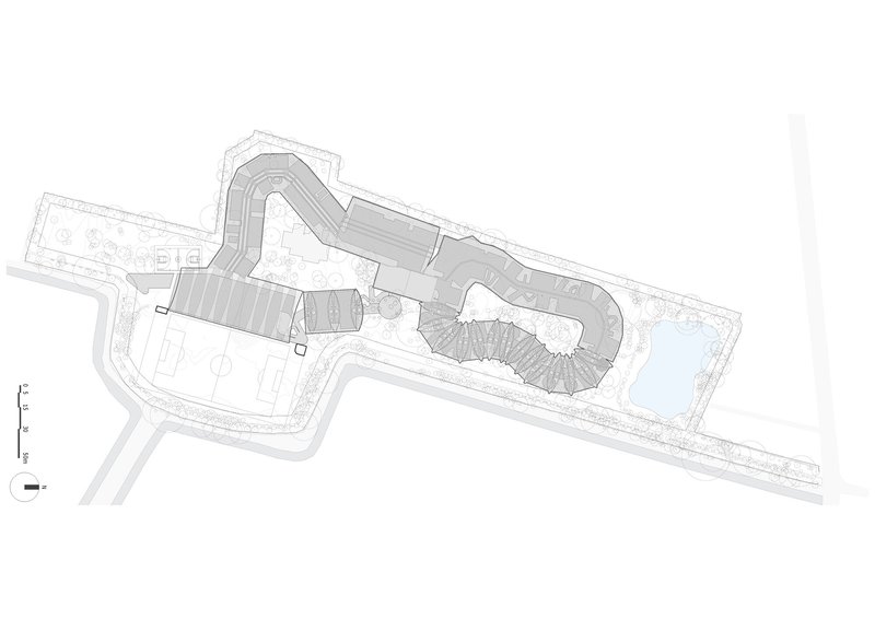 Site plan drawing showing the curved building footprint with roof pattern and adjacent landscape elements