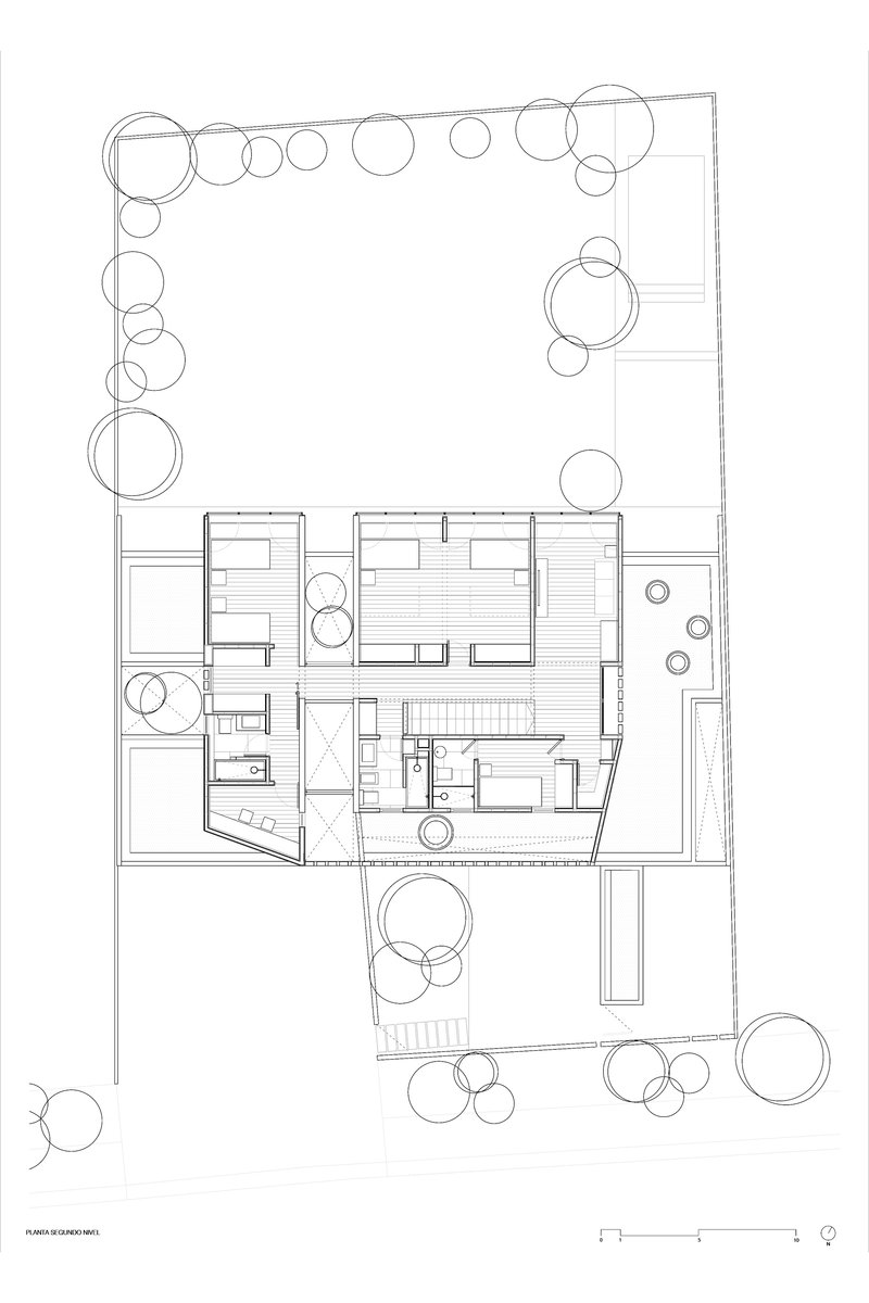 Upper floor plan drawing showing bedroom layout with central stairwell and landscaped perimeter
