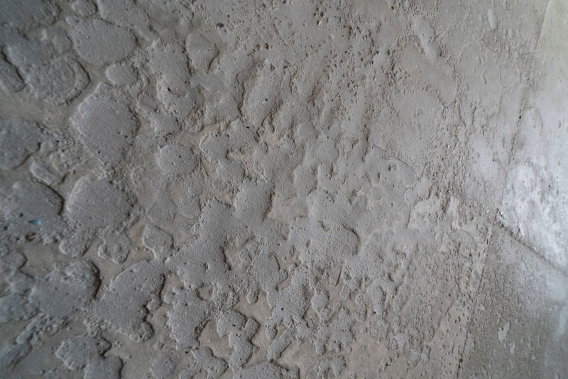 Close-up of board-formed concrete surface showing wood grain texture and tie-hole pattern