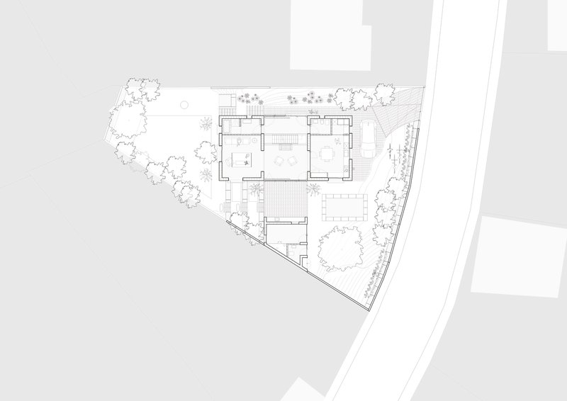 Ground floor plan drawing showing interior rooms surrounded by landscaped gardens on a triangular plot