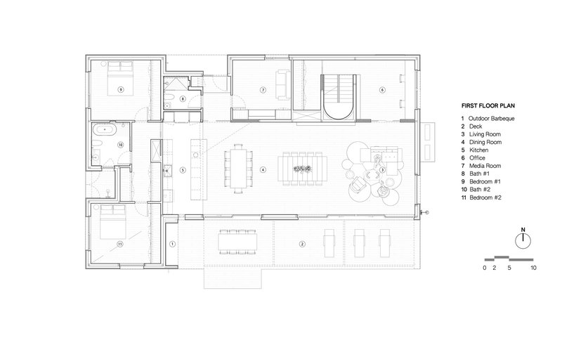 First floor plan drawing showing open living and dining areas with bedrooms and bathrooms