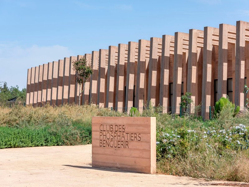 Vertical timber fin screen wrapping the facade with wildflowers and grasses in the foreground