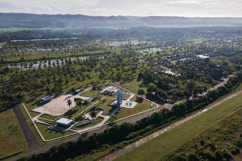 Aerial view of the public park complex within a curving perimeter road and palm plantation