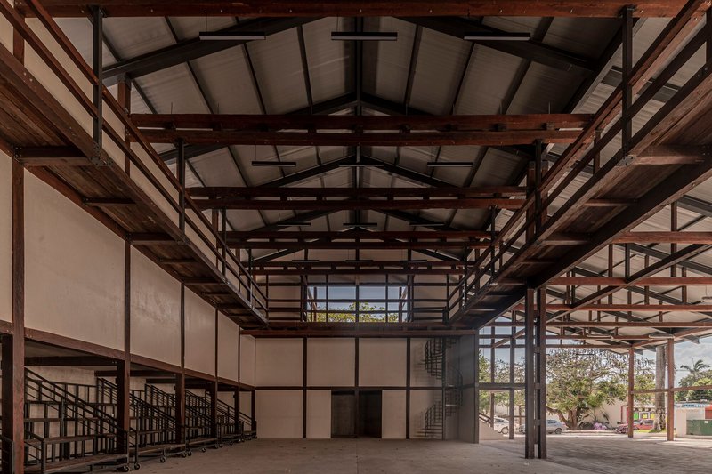 Interior hall with double-height ceiling showing timber roof structure and spiral staircase with glazed walls