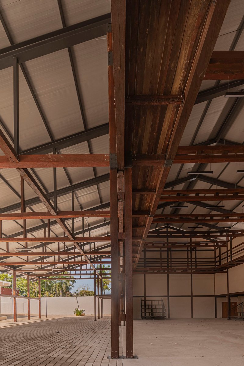 Close-up of timber beam and steel column connection beneath the gridded ceiling structure