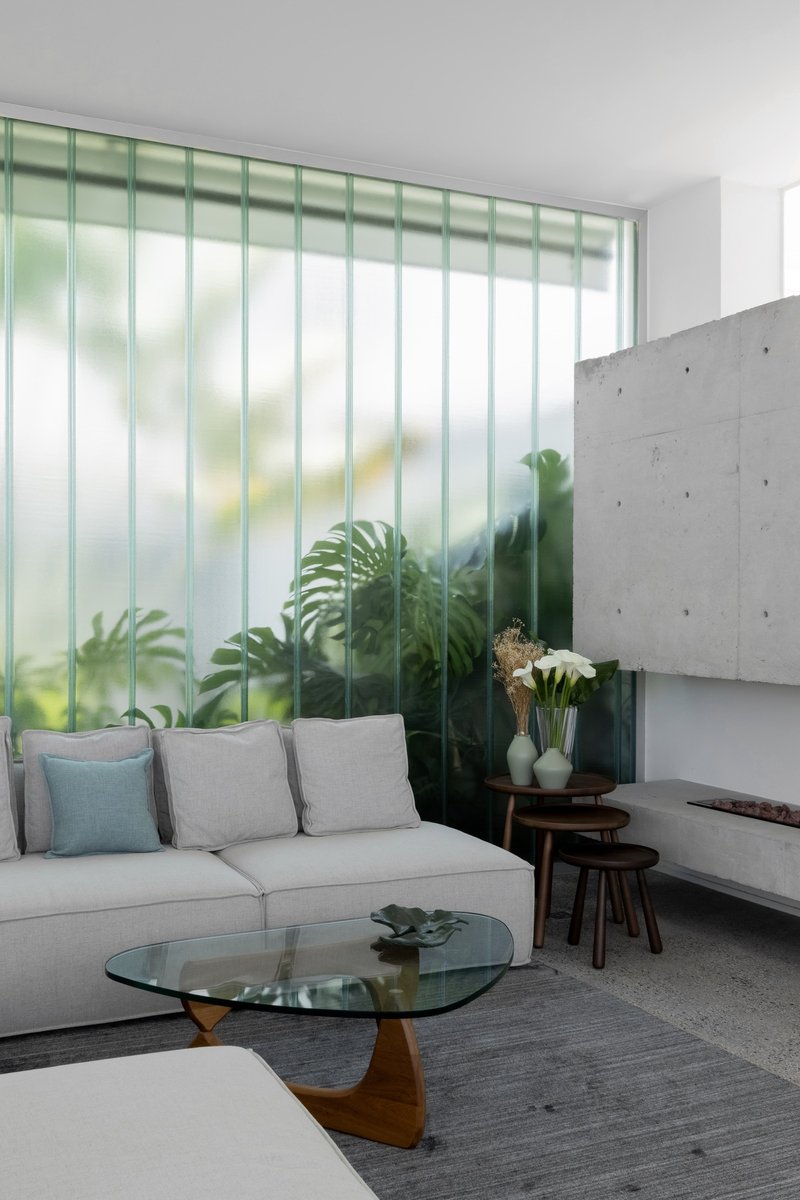 Living room with translucent vertical glass panels diffusing light from the garden outside