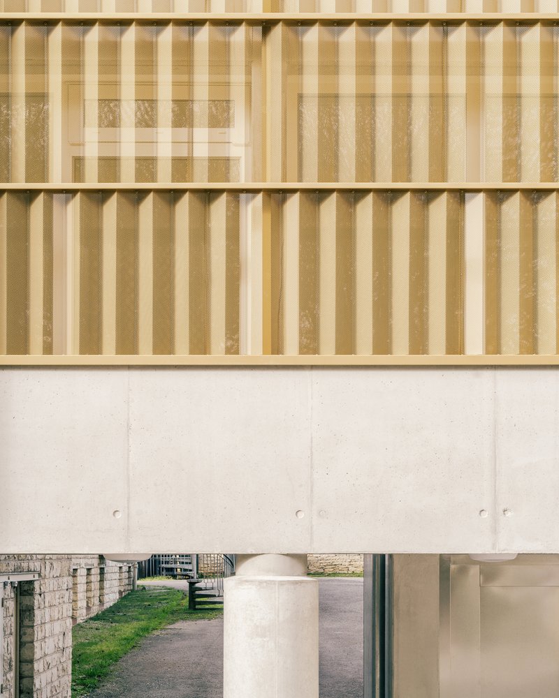 Timber batten screen above a concrete beam with a glimpse of courtyard through the opening below