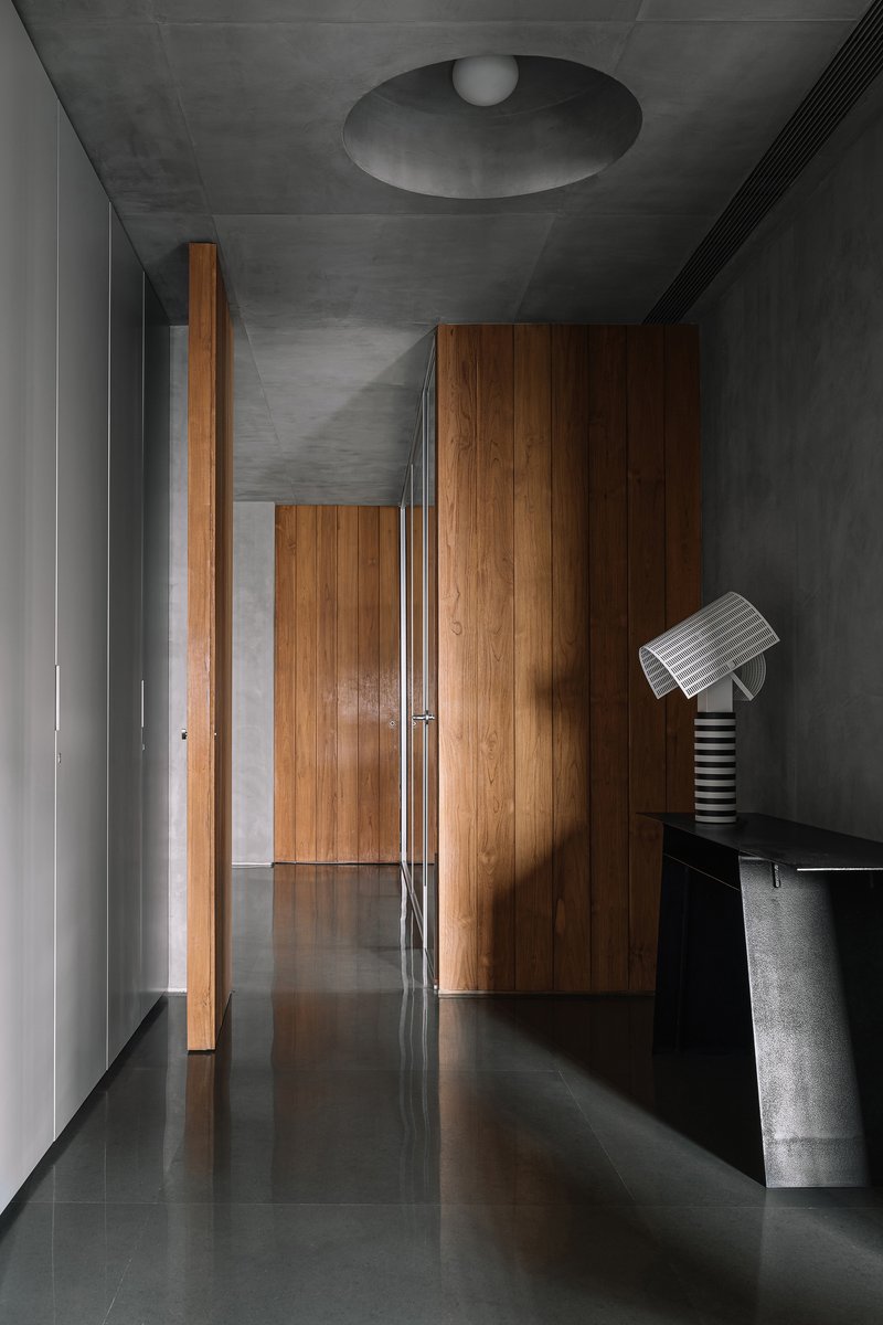 Hallway with polished dark floor reflecting timber cabinetry and a circular ceiling recess with pendant light
