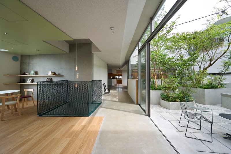 Open-plan interior with perforated metal partition and sliding glass doors opening to a terrace