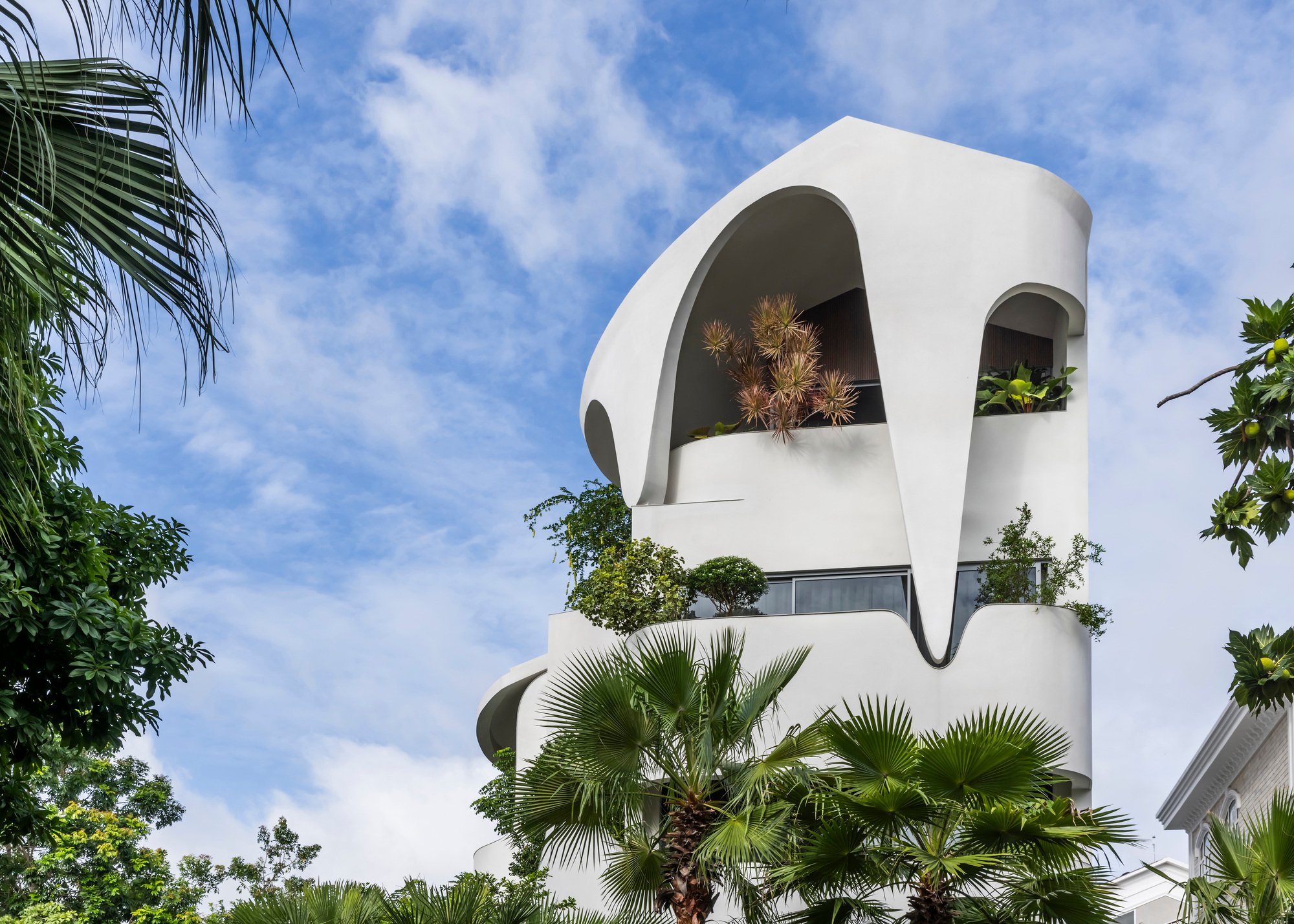 23o5Studio Wraps a Six-Bedroom Ho Chi Minh City Home in Curving White Terraces and Tropical Greenery