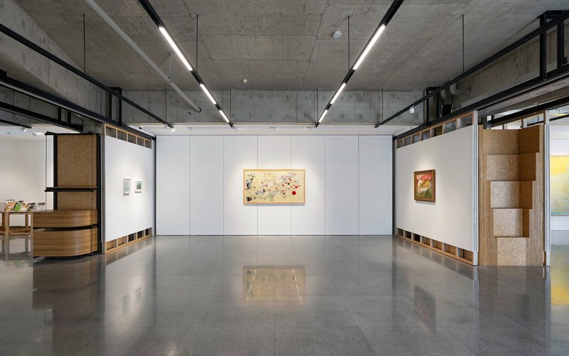Exhibition hall with modular white wall system and polished concrete floor reflecting overhead lighting