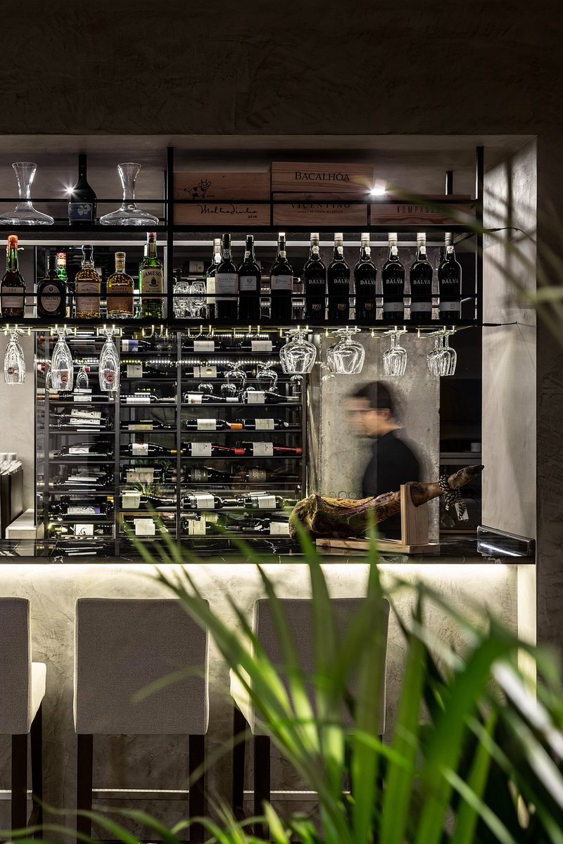 Linear circulation meets curated display, where wine storage becomes an architectural feature.