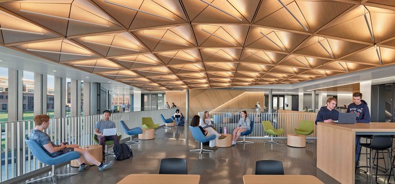 Upper-level lounge space with faceted acoustic wood ceiling and students in casual seating
