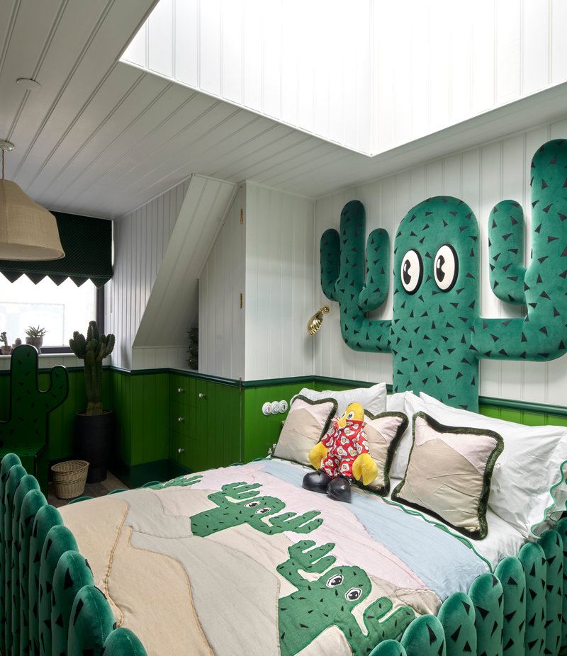Bedroom with green cabinetry and cactus-themed wall decoration beneath white paneled ceiling