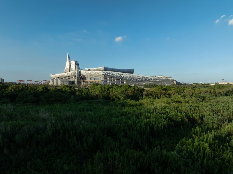 The complex viewed from a field of green vegetation in late afternoon light