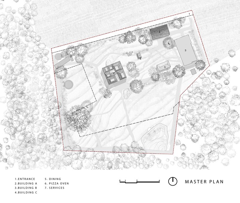Site plan drawing showing multiple buildings and pathways within an irregular property boundary surrounded by trees