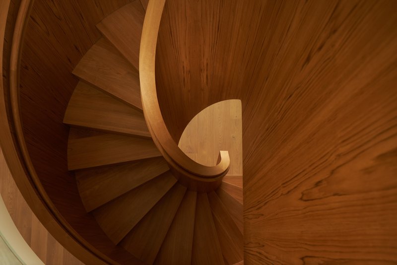 Looking down the spiral staircase showing the radiating timber treads and curved handrail from above