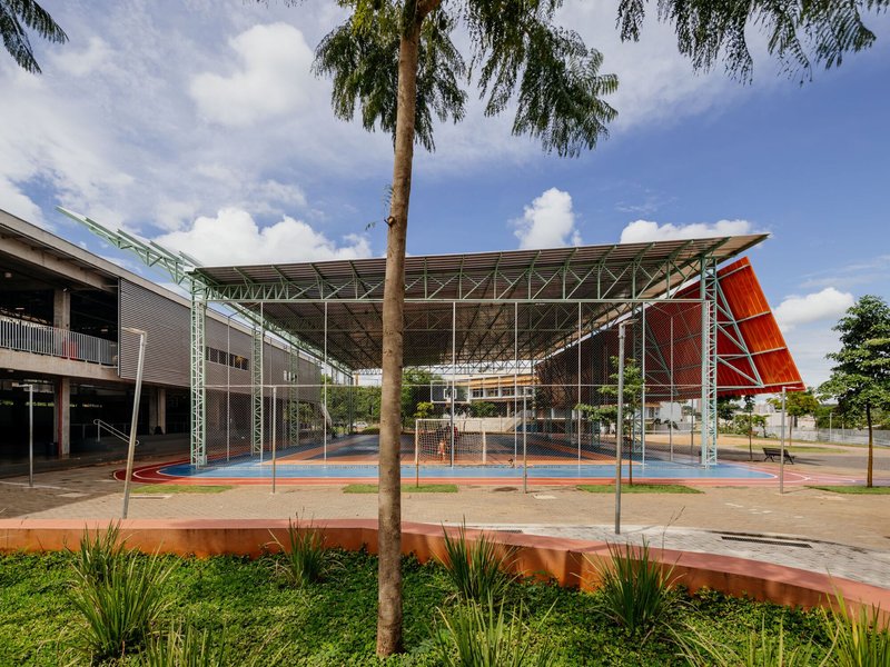 Central courtyard enclosed by the steel truss canopy with palm trees and planting beds framing the view