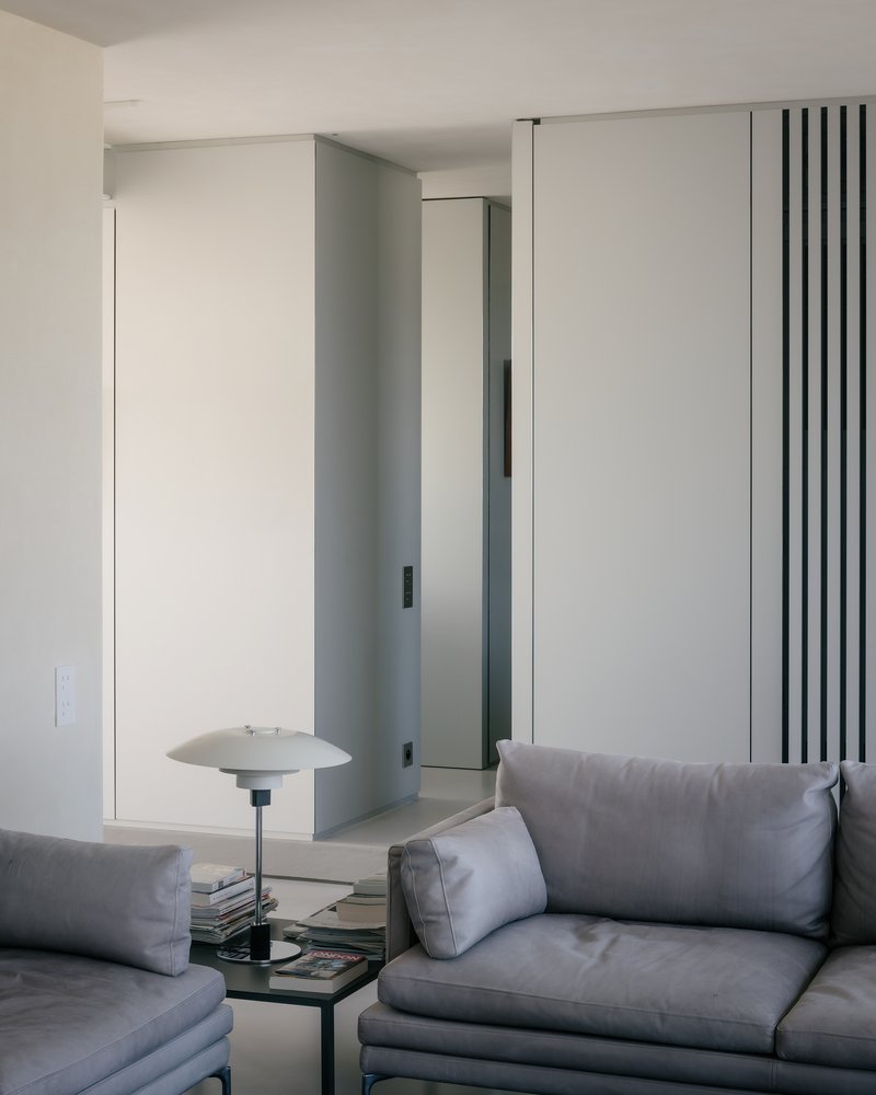 Living room with white partition walls featuring vertical black slat detailing