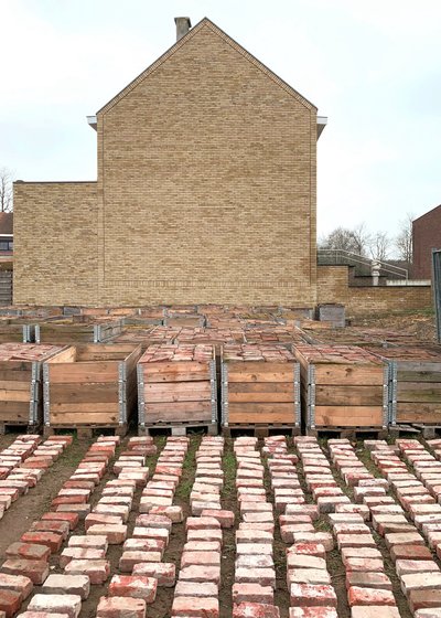 This architectural image showcases a brick building facade with a gable roof, complemented by stacks