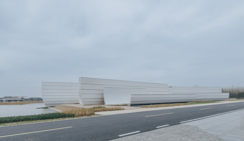 Roadside view of the horizontal striped white volume alongside grasses and water