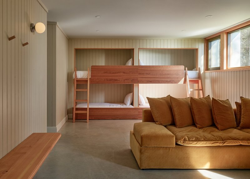 Bunkroom with built-in timber beds recessed into tongue-and-groove wall niches