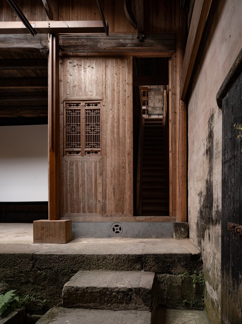 Timber door with latticed panels beneath exposed wooden beams and stone threshold steps