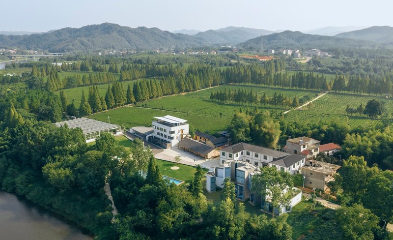 Aerial view of the compound surrounded by farmland, tree rows, and rolling hills