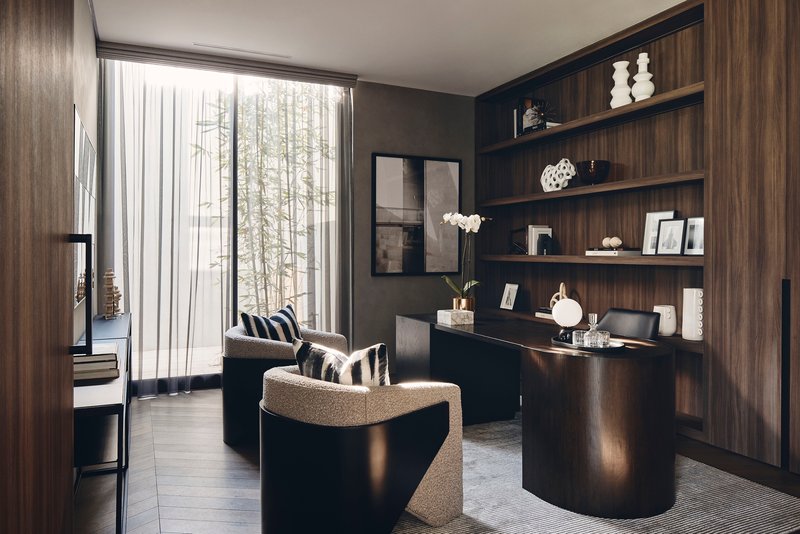 Study nook with dark timber shelving and desk beneath a window with sheer curtains