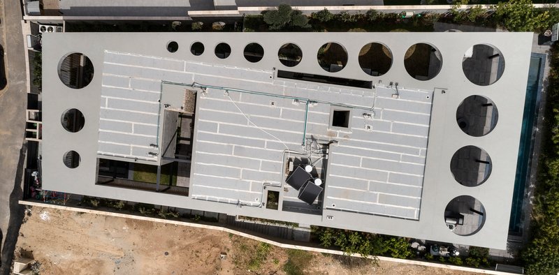 Overhead view of the white roof deck punctuated by circular openings of varying diameters