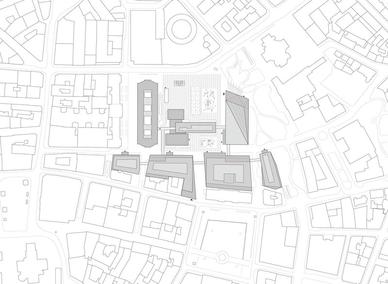 Site plan drawing showing clustered buildings with varied roof geometries within an urban block