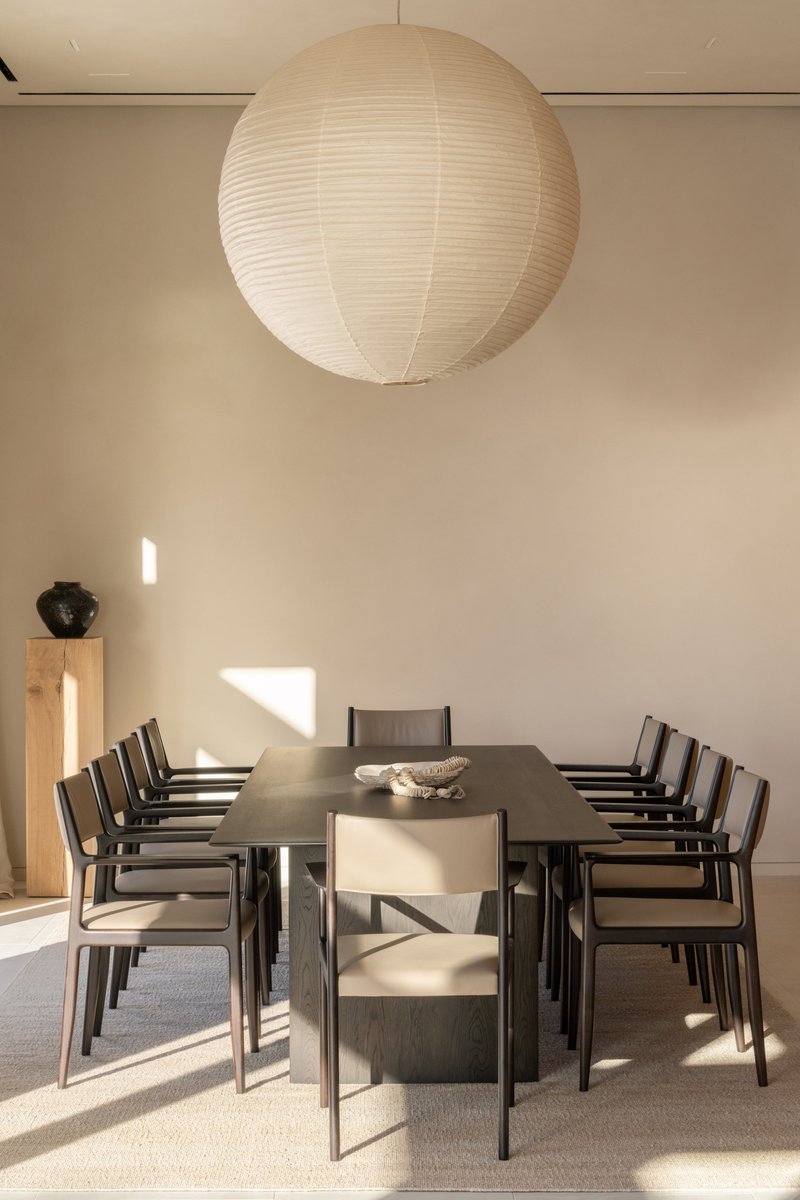 Dining room with dark timber table and paper globe pendant casting morning sunlight patterns